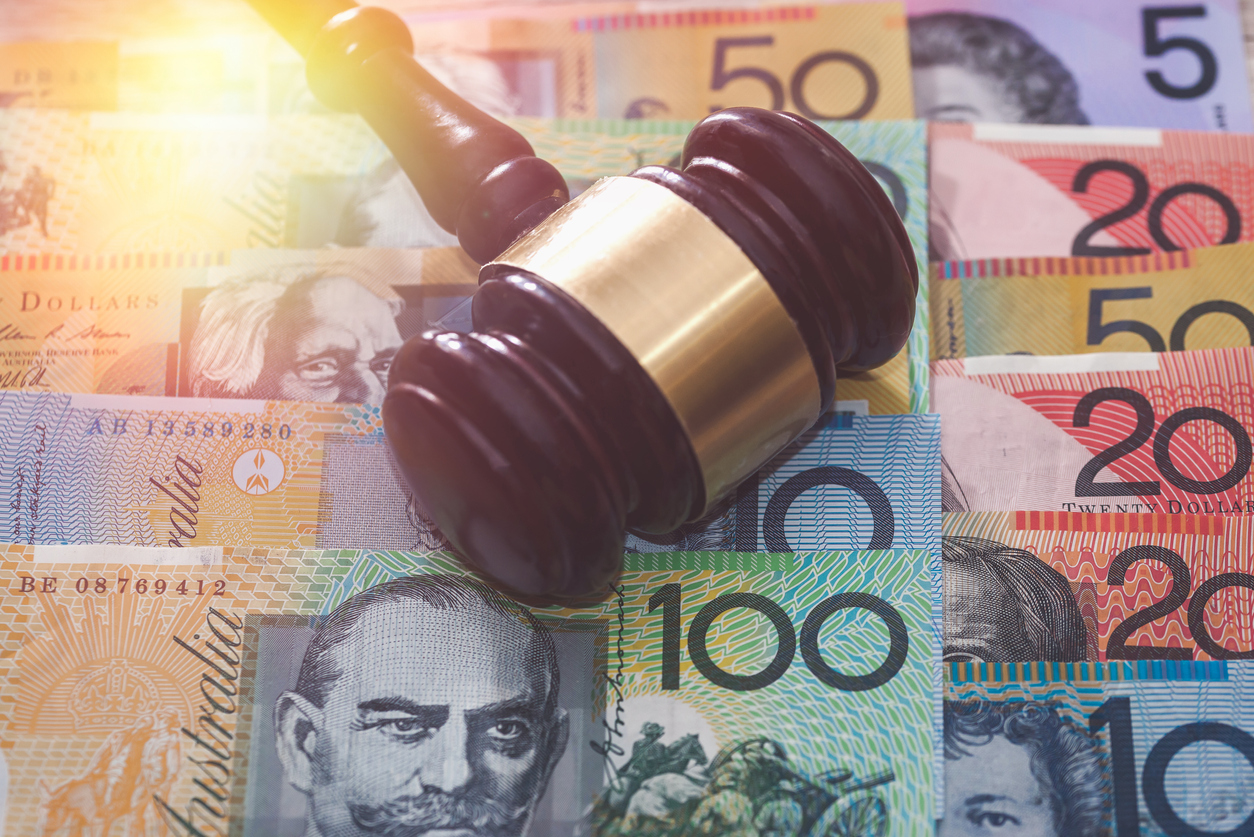 australian dollars with a judges gavel. PointsBet Faces $25,000 Fine in NJ for Gaming Law Violations